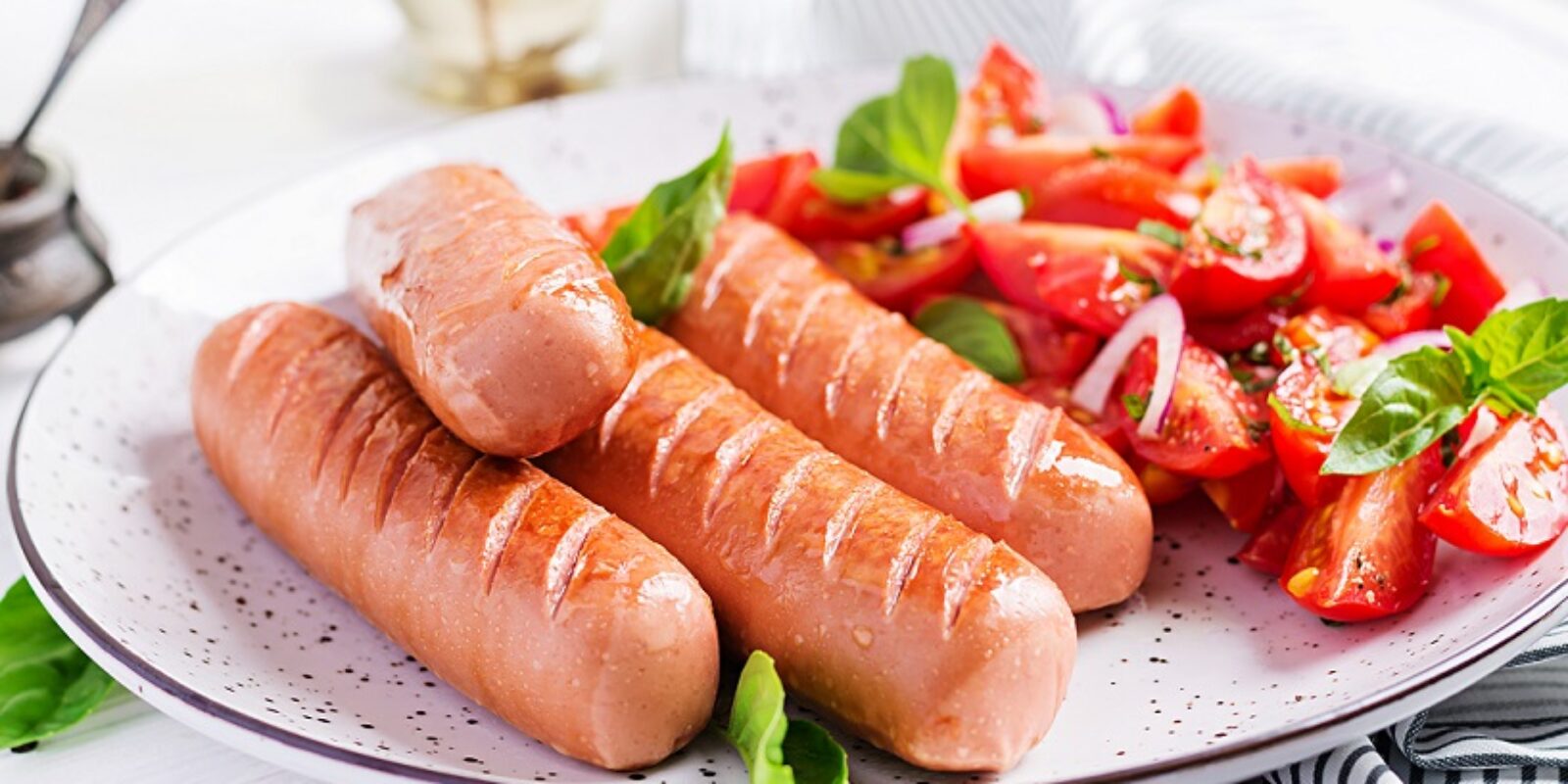 Grilled sausage with tomatoes, basil salad and red onions. BBQ menu.