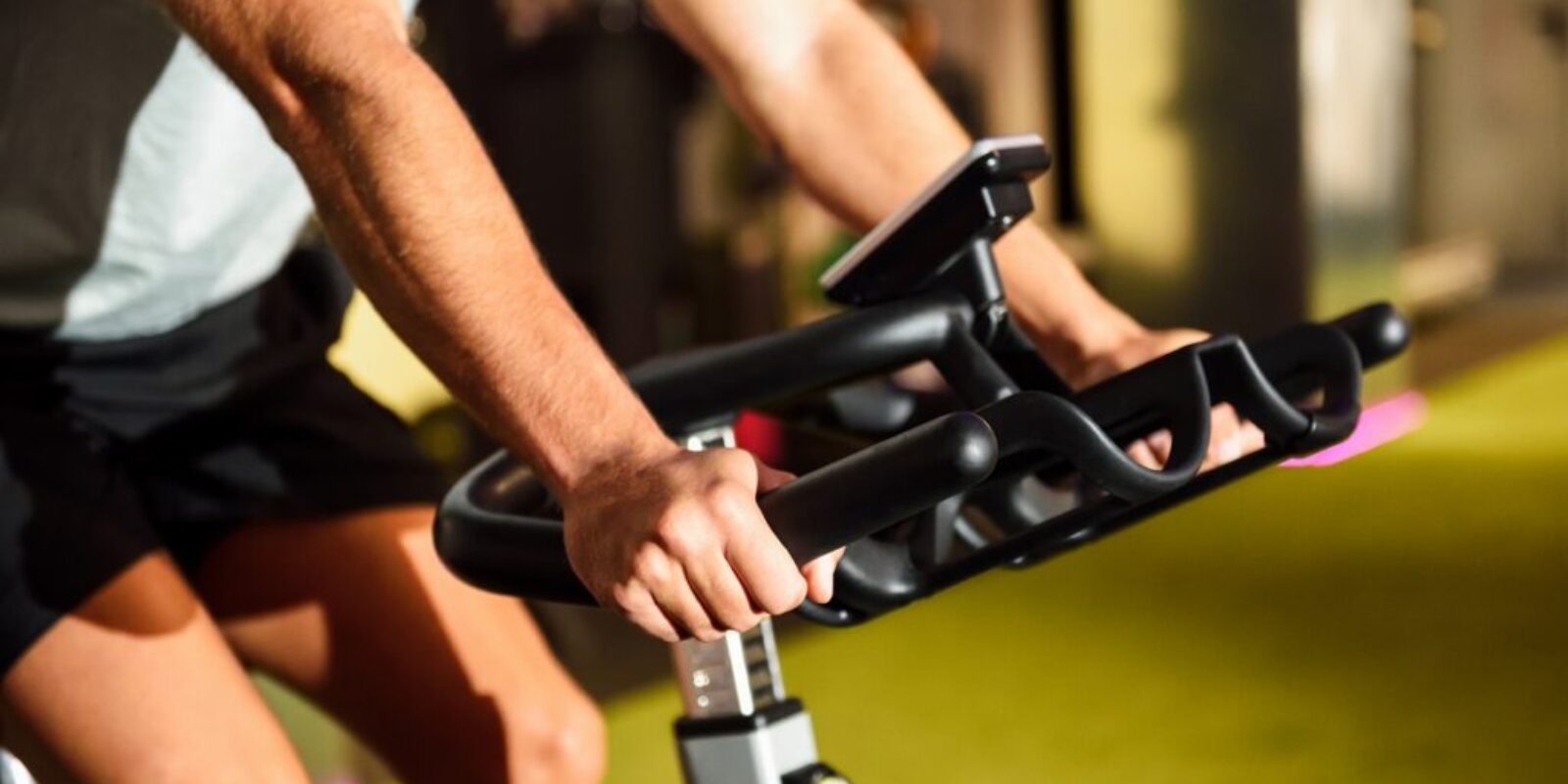 Hands of a man training at a gym doing cyclo indoor.