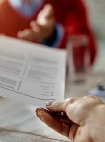 Close-up of a candidate giving his CV while applying for a job.