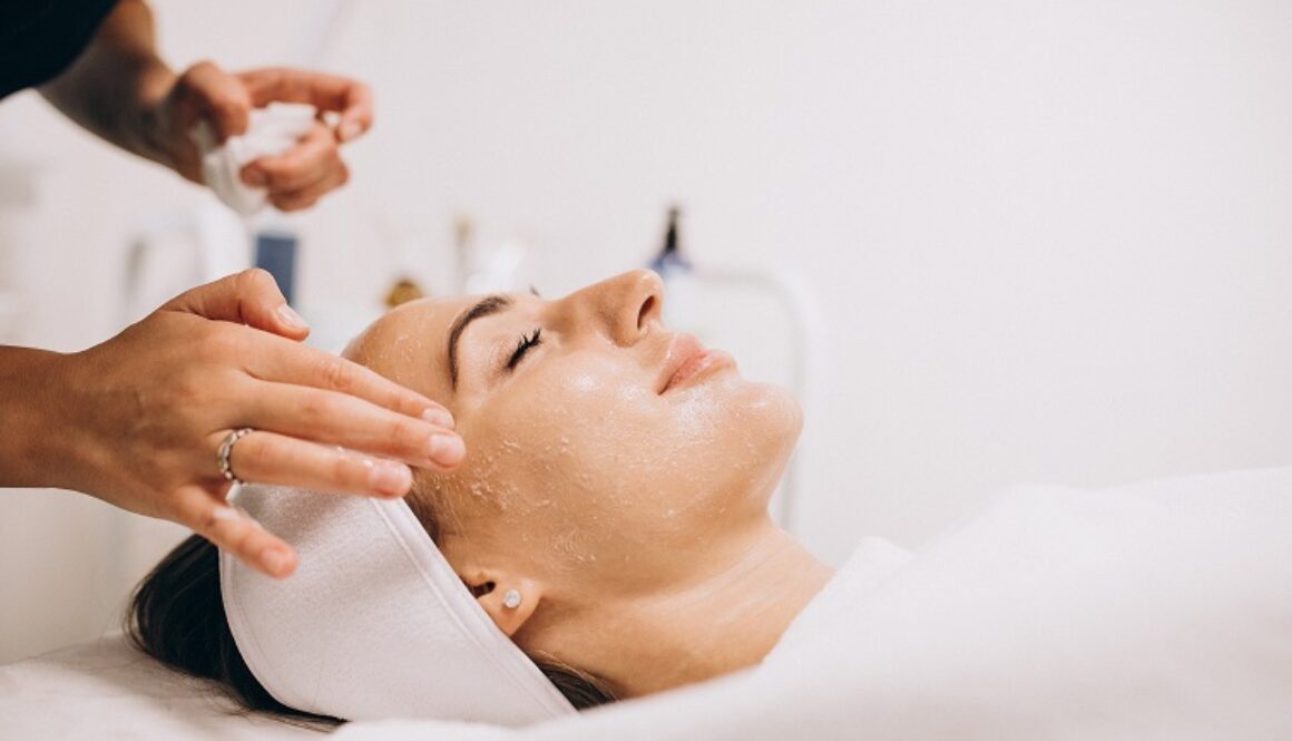 Cosmetologist cleaning face of a woman in a beauty salon