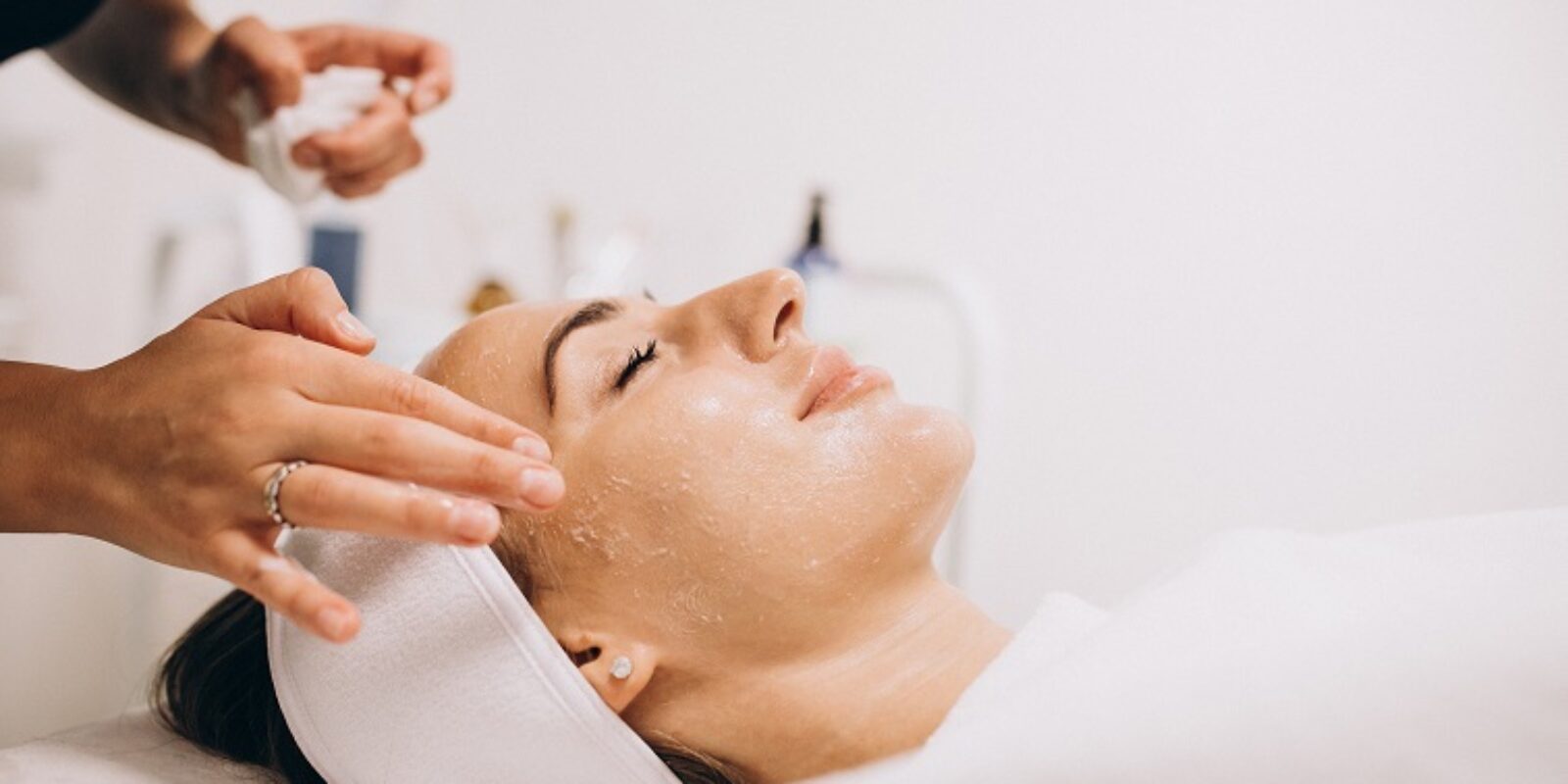 Cosmetologist cleaning face of a woman in a beauty salon