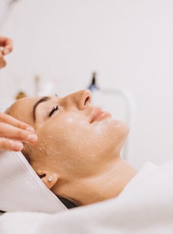 Cosmetologist cleaning face of a woman in a beauty salon