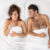 Happy newlywed couple enjoy comfort in bed, look at each other with love and joy, lying in bed under white bedclothes, make plans for future, have romantic relationships, feel good and relaxed